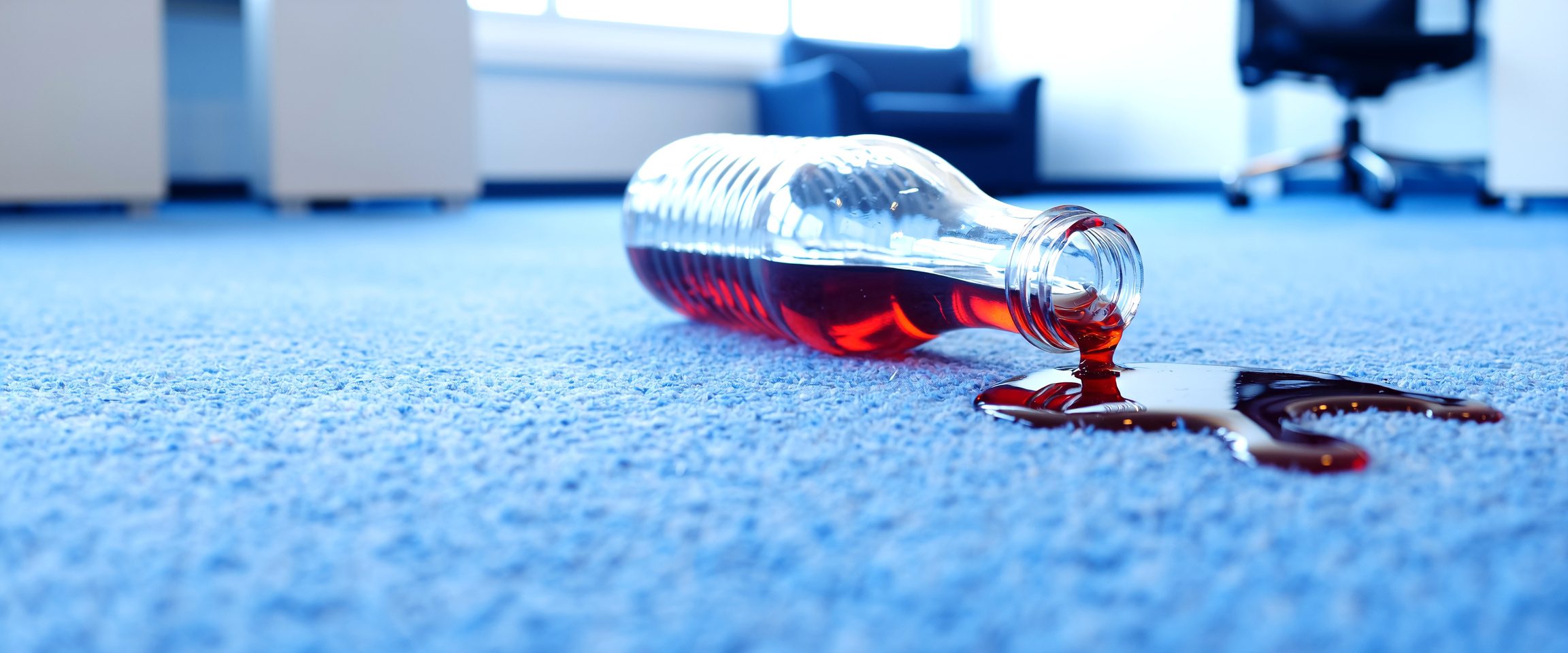 Red cordial spill on carpet being treated for stain removal in a commercial cleaning setting in Canberra